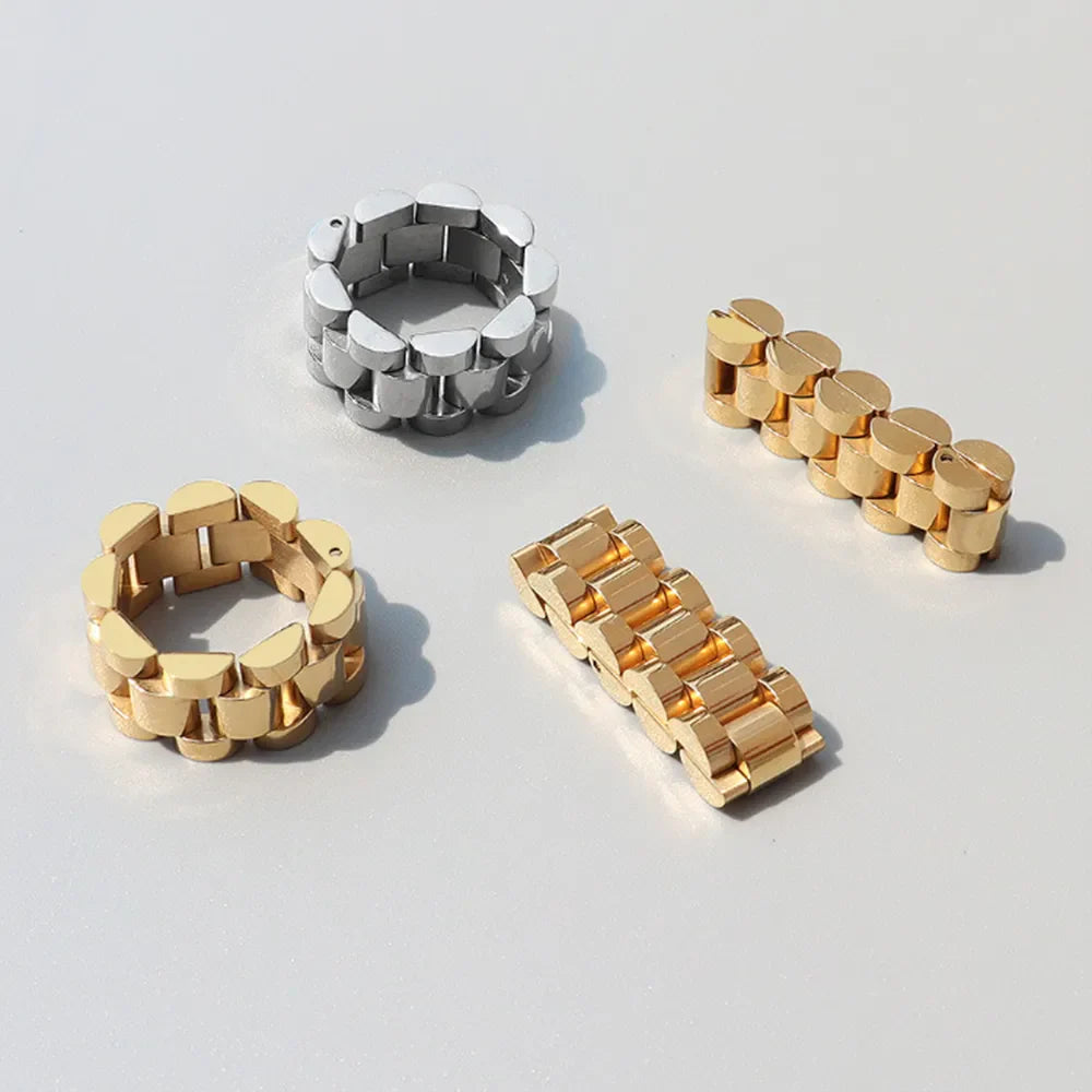 Watch link statement rings in gold and silver metal, inspired by watch bands.