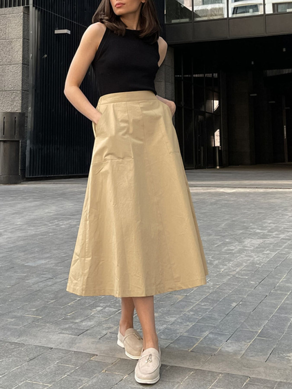 High-waisted A-line skirt in tan cotton with large front pockets.