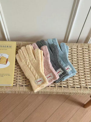 Luxurious cable knit gloves in yellow, pink, gray, and blue with lace trim detail.