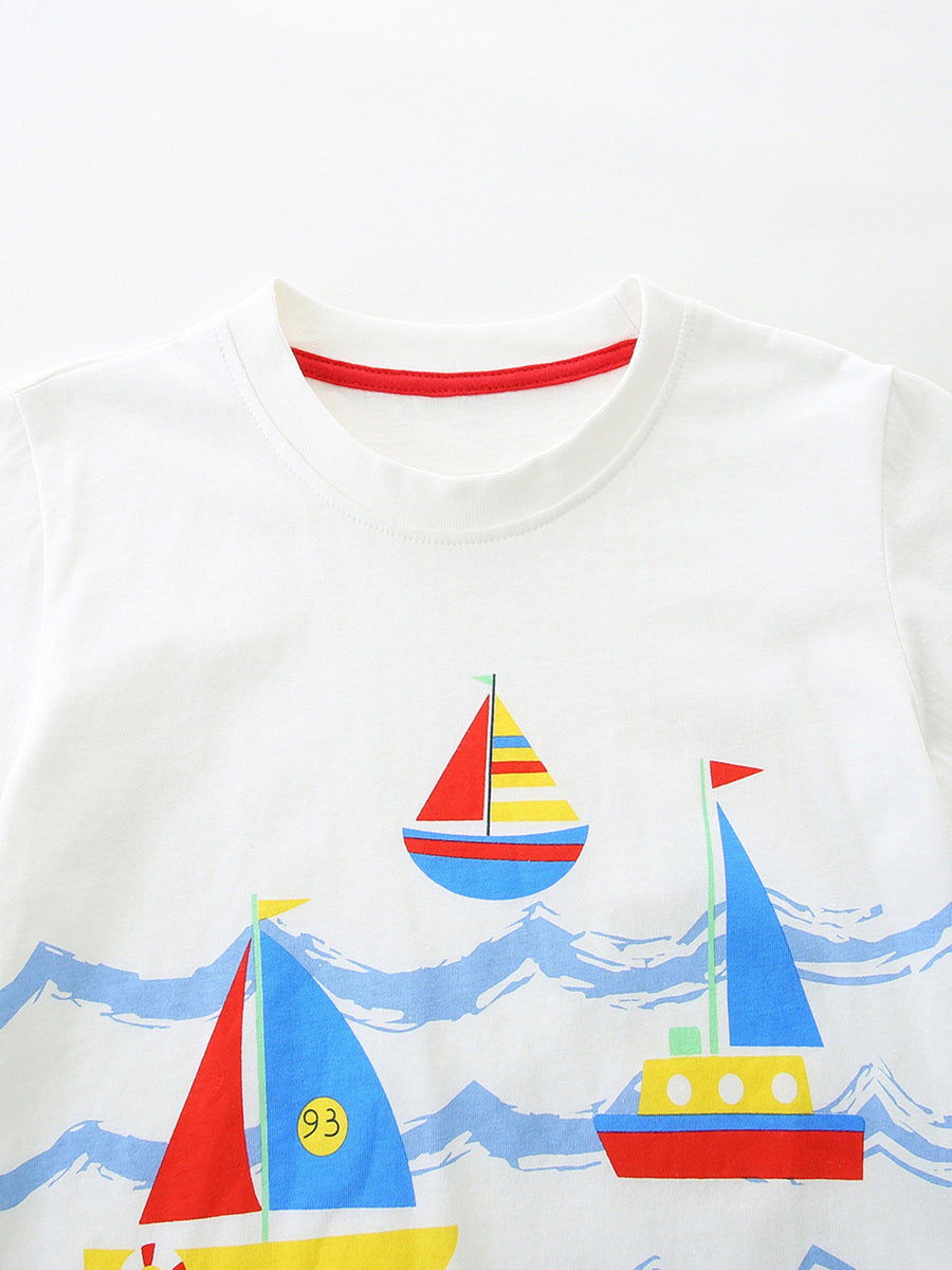White cotton toddler tee with colorful sailboat print and red neckline trim.