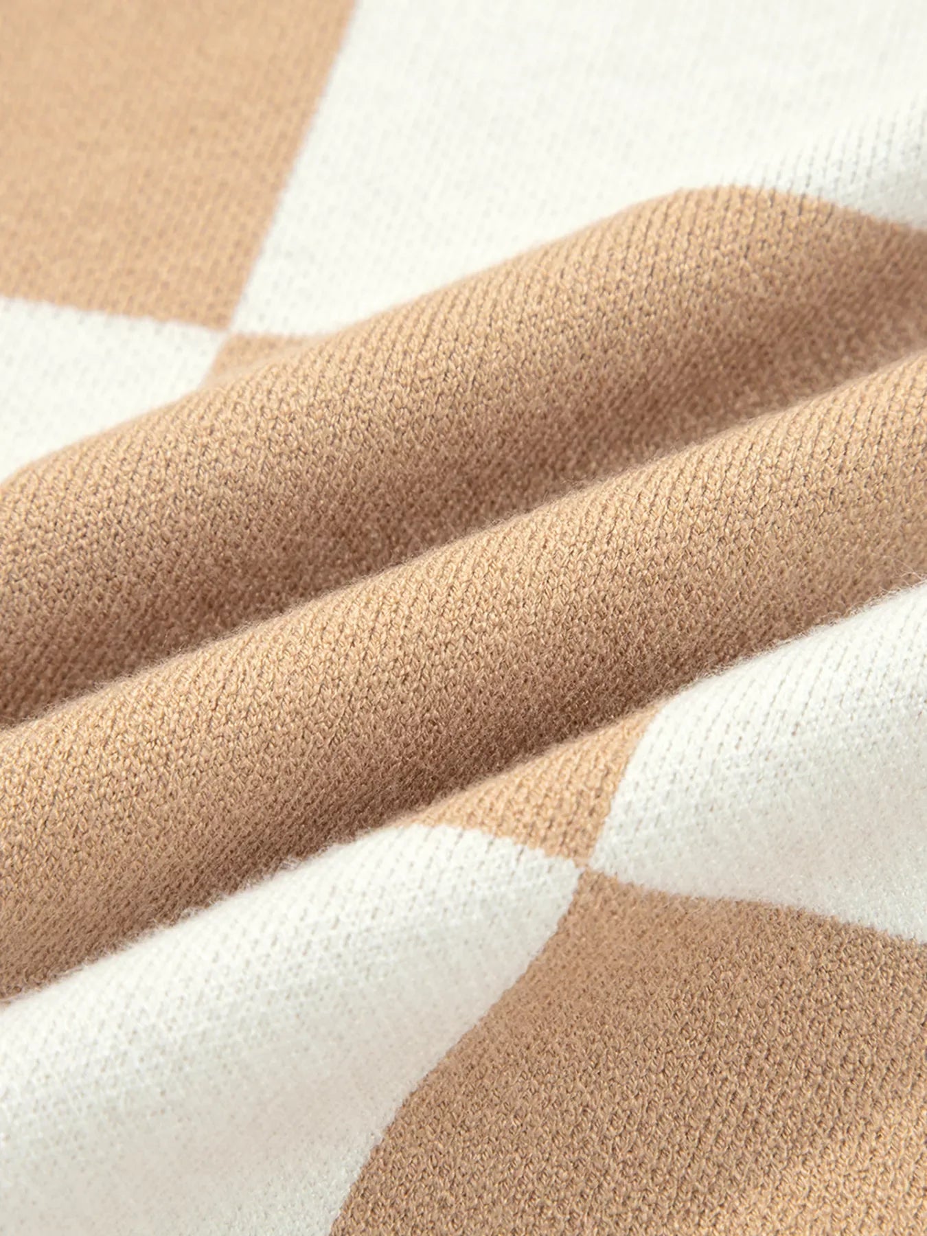 Drop shoulder sweater in camel and white argyle knit fabric.