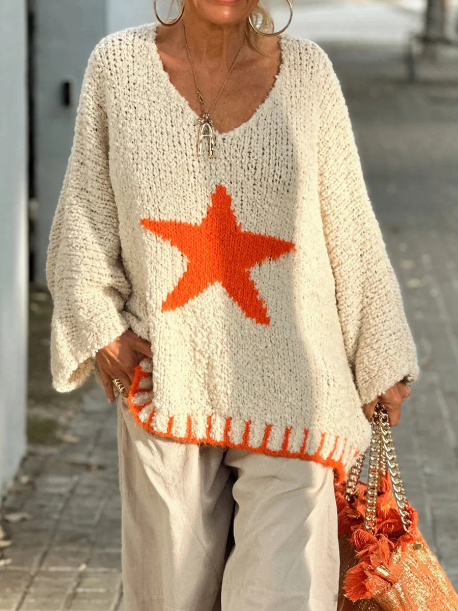 Cream knit v-neck pullover with orange star detail and ribbed hem.
