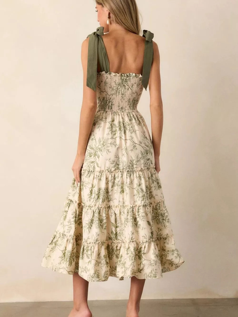 Floral tiered midi dress with smocked bodice and tie straps in cream with green botanical print.