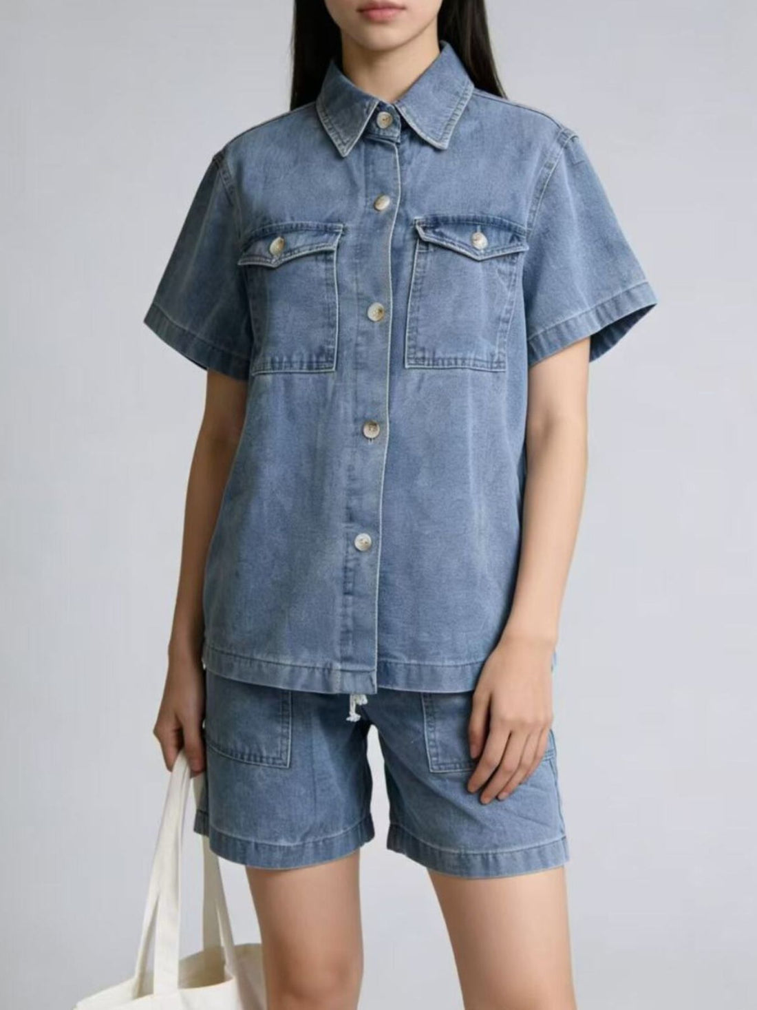 Button-up denim top and shorts set in sky blue with collared neckline and short sleeves.
