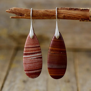 Stone grain teardrop dangle earrings with red and white stripes and brown and orange stripes.