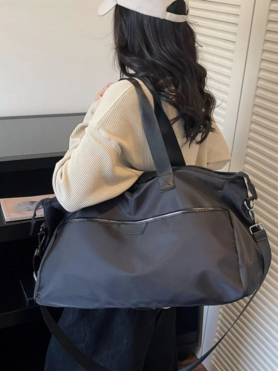 Spacious dark grey Oxford cloth travel duffle bag with front zip pocket and adjustable strap.