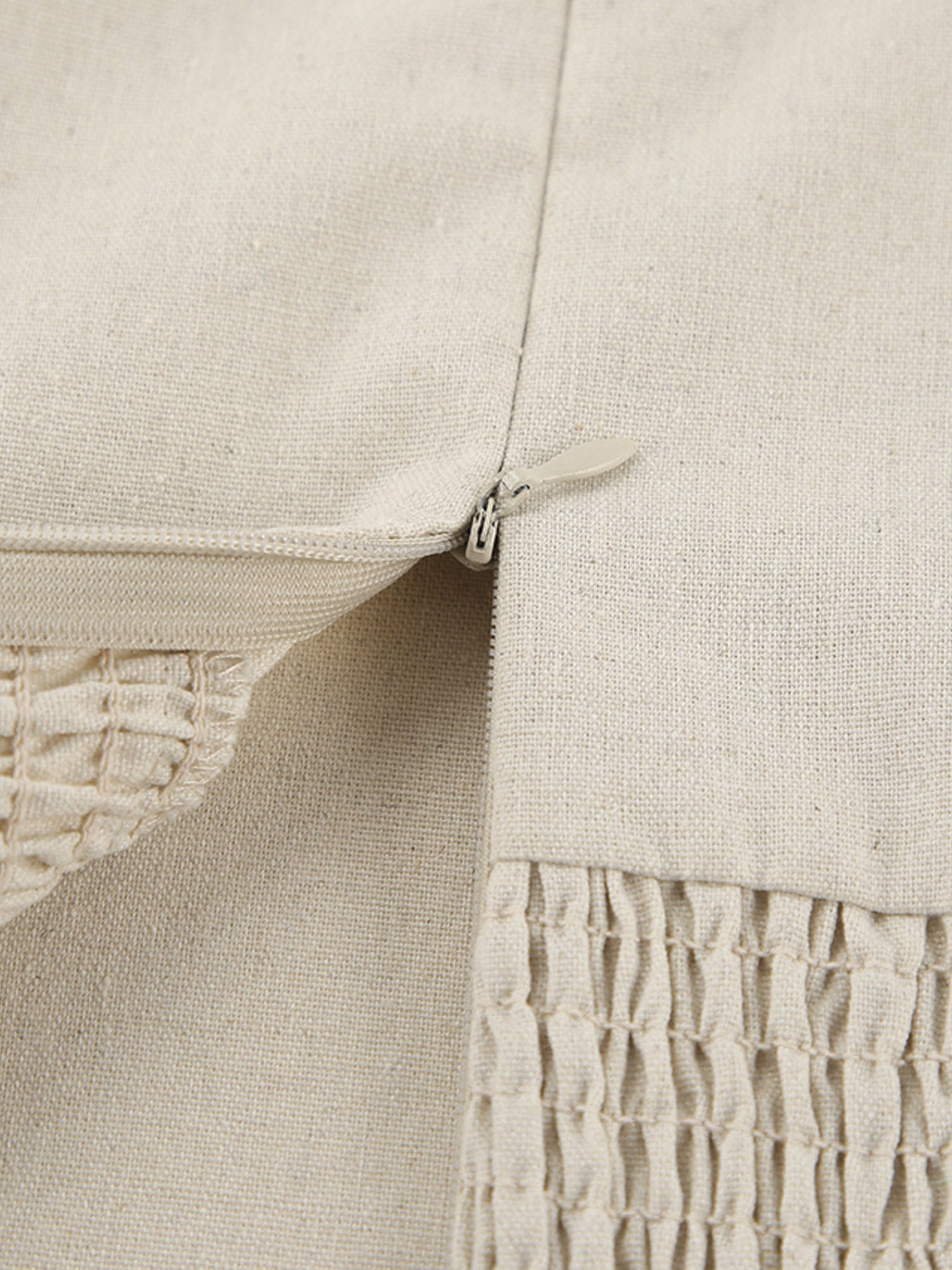 Beige cotton smocked tube dress detail showing zipper and smocked texture.