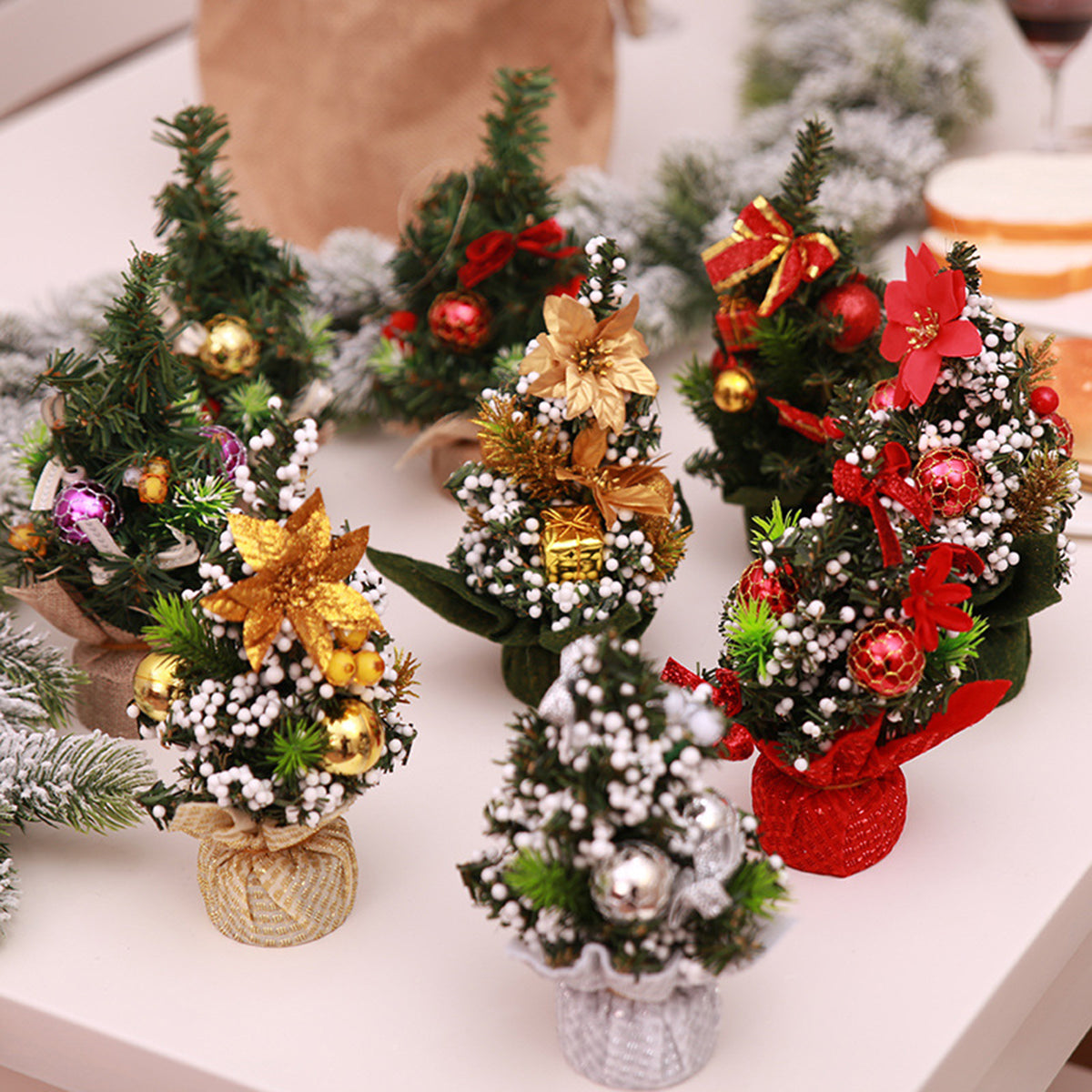 Miniature festive forest holiday centerpieces with colorful ornaments and bows.