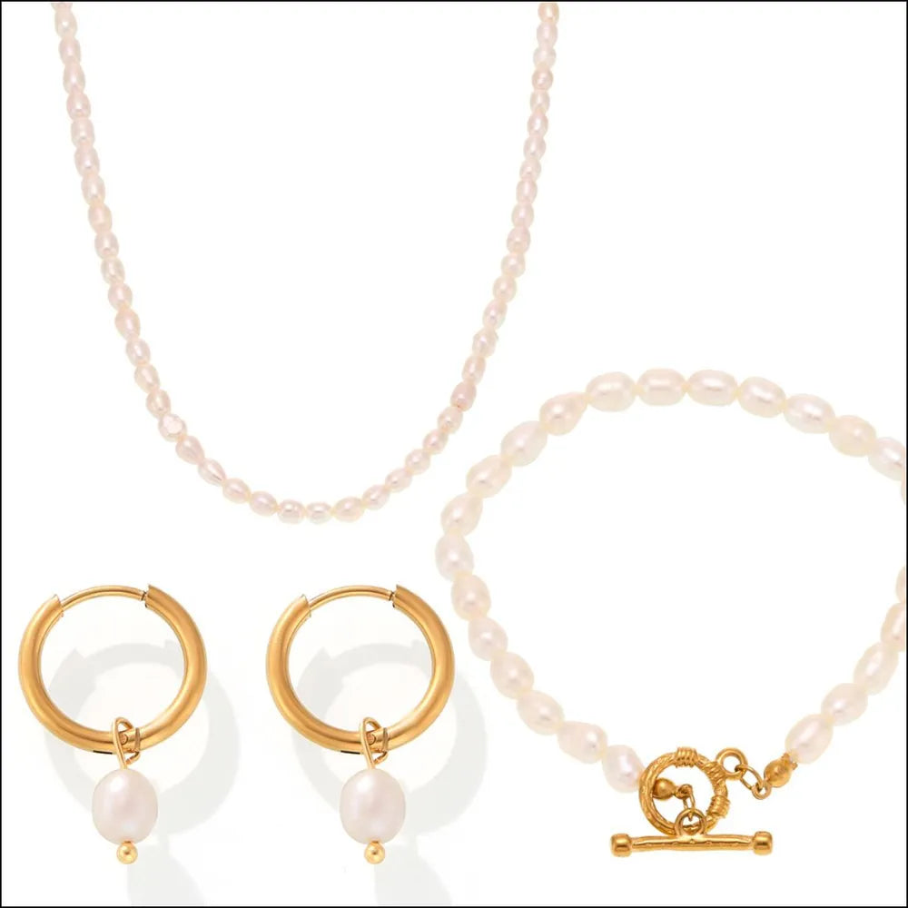 Gold pearl jewelry set with necklace, bracelet, and hoop earrings.