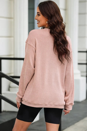 Dusty pink ribbed sweatshirt with crew neck and long sleeves, casual style.