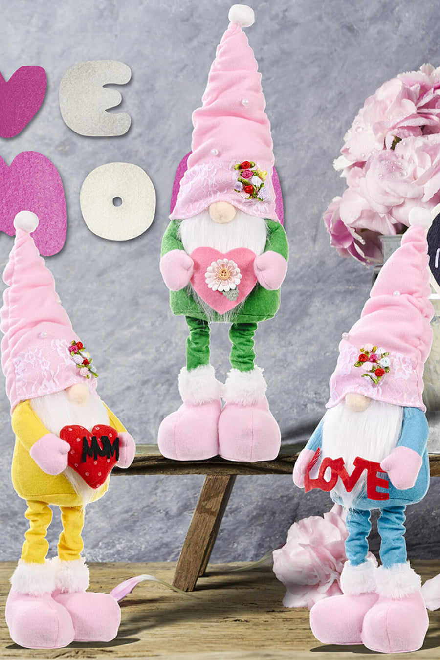 Garden gnome with pink hat, holding heart, in yellow, green, and blue outfits.