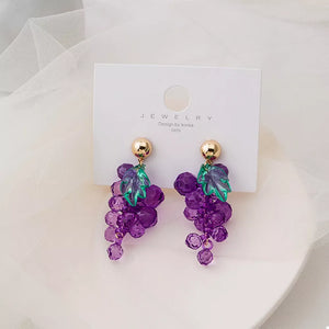 Grape-inspired beaded dangle earrings with gold studs and green acrylic leaves.