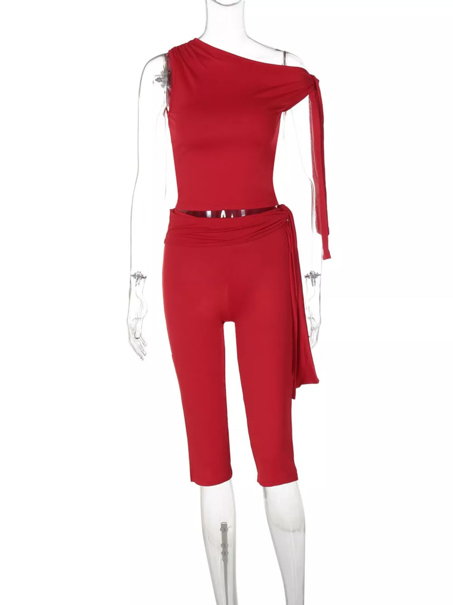Red asymmetrical one-shoulder top and capri pants set with draped detail