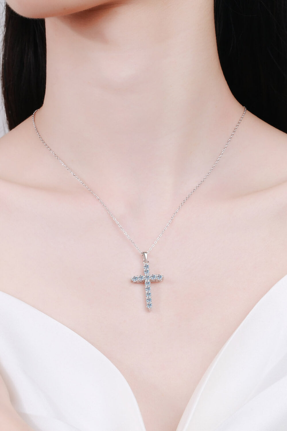 Silver pavé diamond cross pendant necklace with a delicate chain.