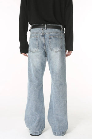 Flared denim jeans in medium wash with sculpted seam detail and distressed pockets.
