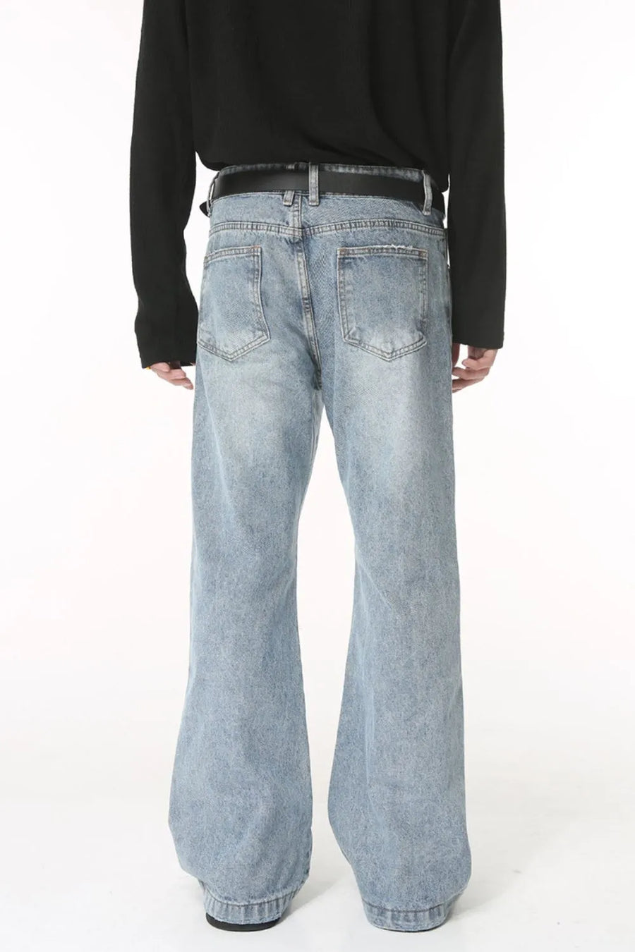 Flared denim jeans in medium wash with sculpted seam detail and distressed pockets.