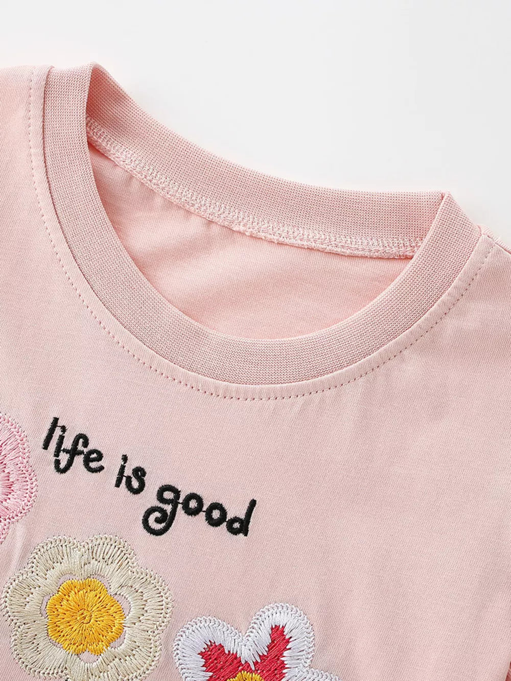 Pink cotton t-shirt with embroidered flowers and "life is good" text.