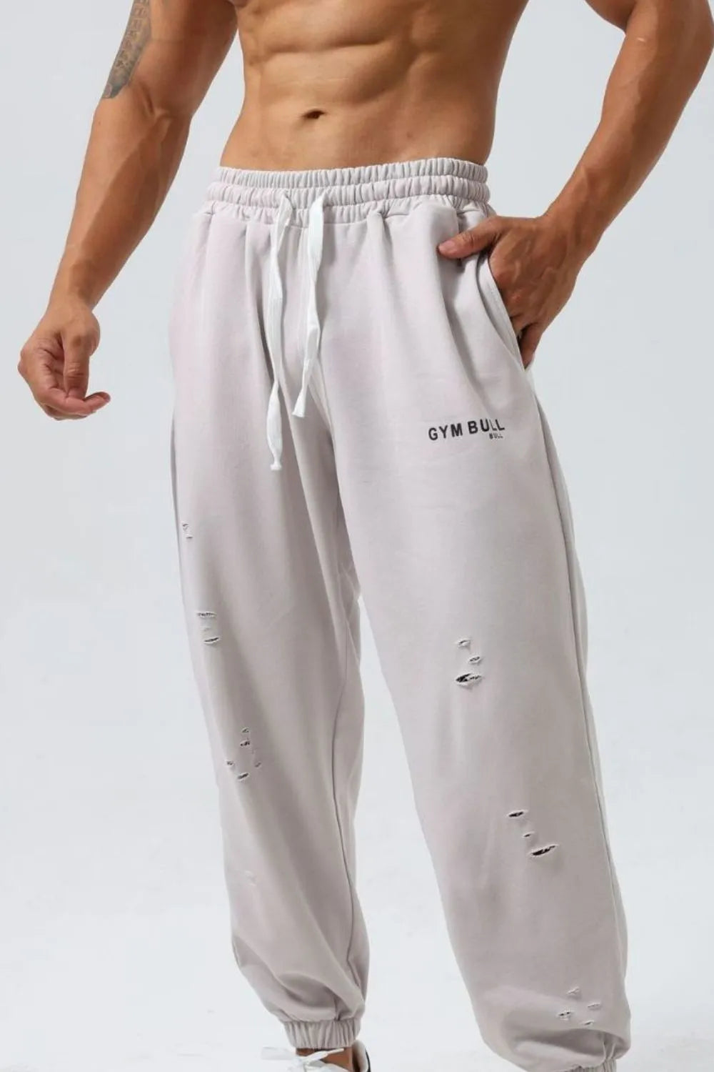 Gray distressed joggers with Gym Bull logo and drawstring waist.