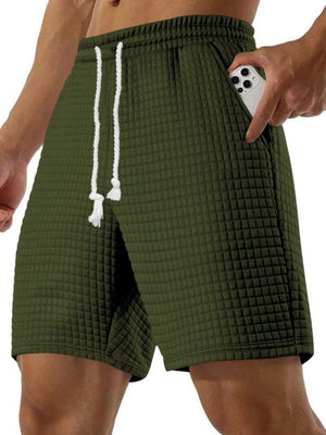 Army green waffle knit relaxed fit shorts with drawstring and side pocket holding a phone