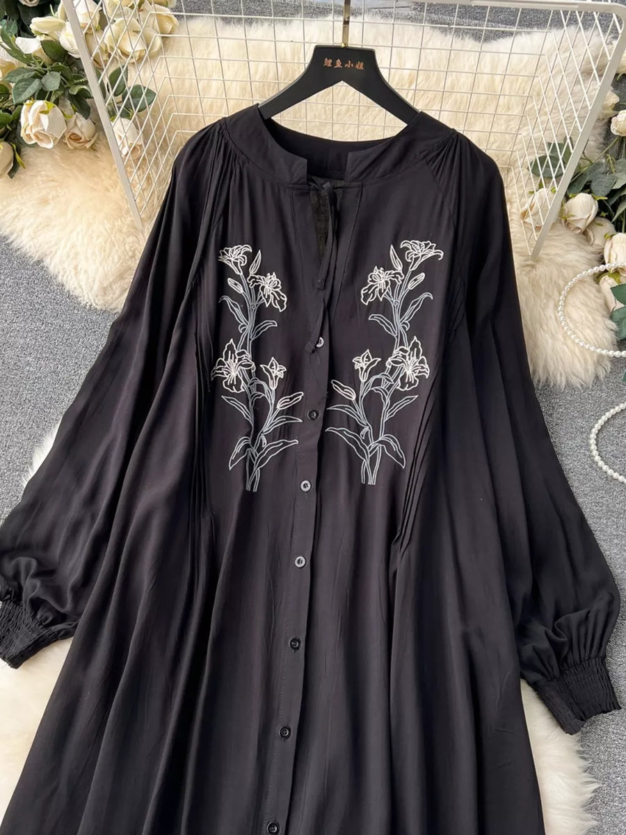 Black embroidered floral maxi dress with tie neck and balloon sleeves.