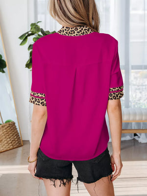 Fuchsia split neck blouse with leopard trim on collar and cuffs.