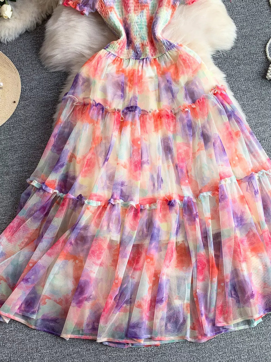 Floral tiered midi dress with smocked bodice in tie-dye colors.