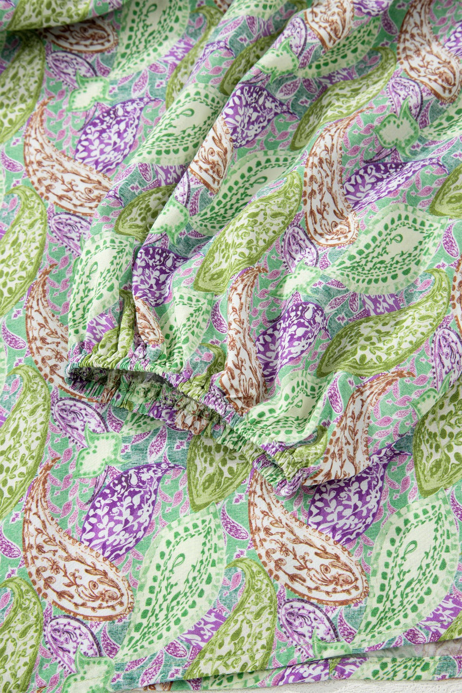 Paisley print puff sleeve blouse with elastic cuff in green, purple, and cream.