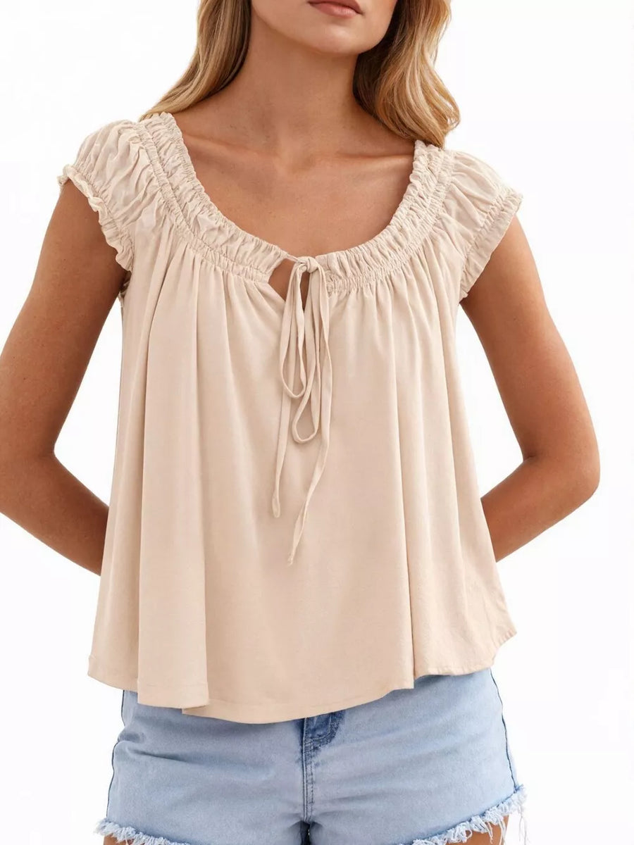 Charming tie-front gathered blouse in beige with a drawstring neckline and short sleeves.