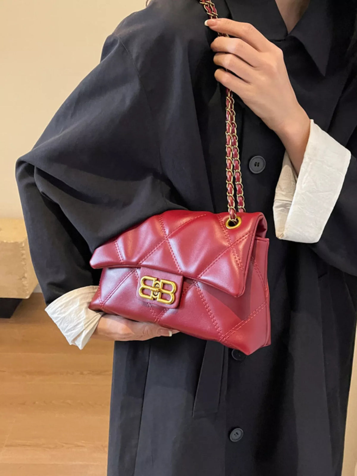 Red quilted flap chain shoulder bag with gold hardware and a turn-lock closure.
