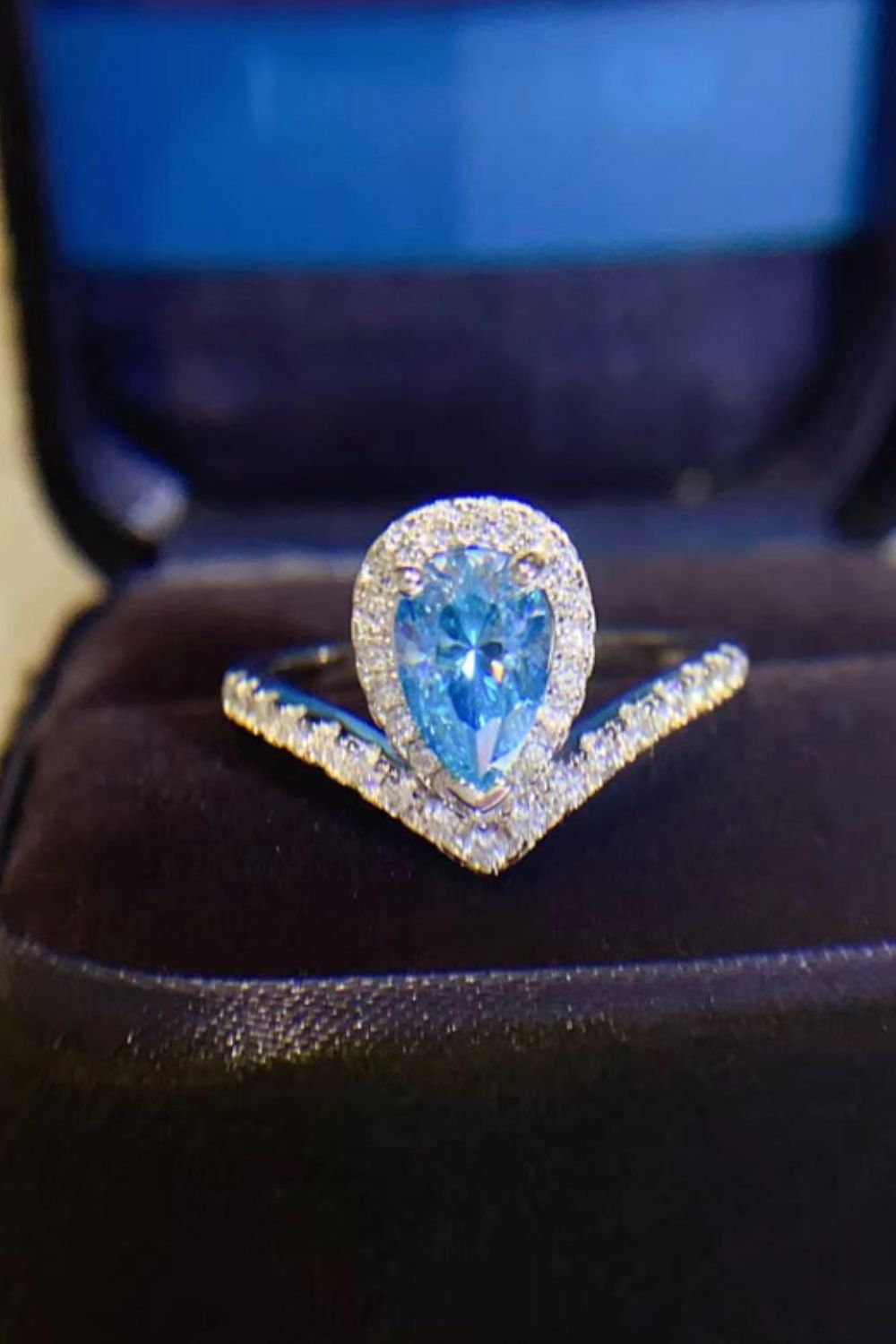 Sky blue pear halo ring with chevron band