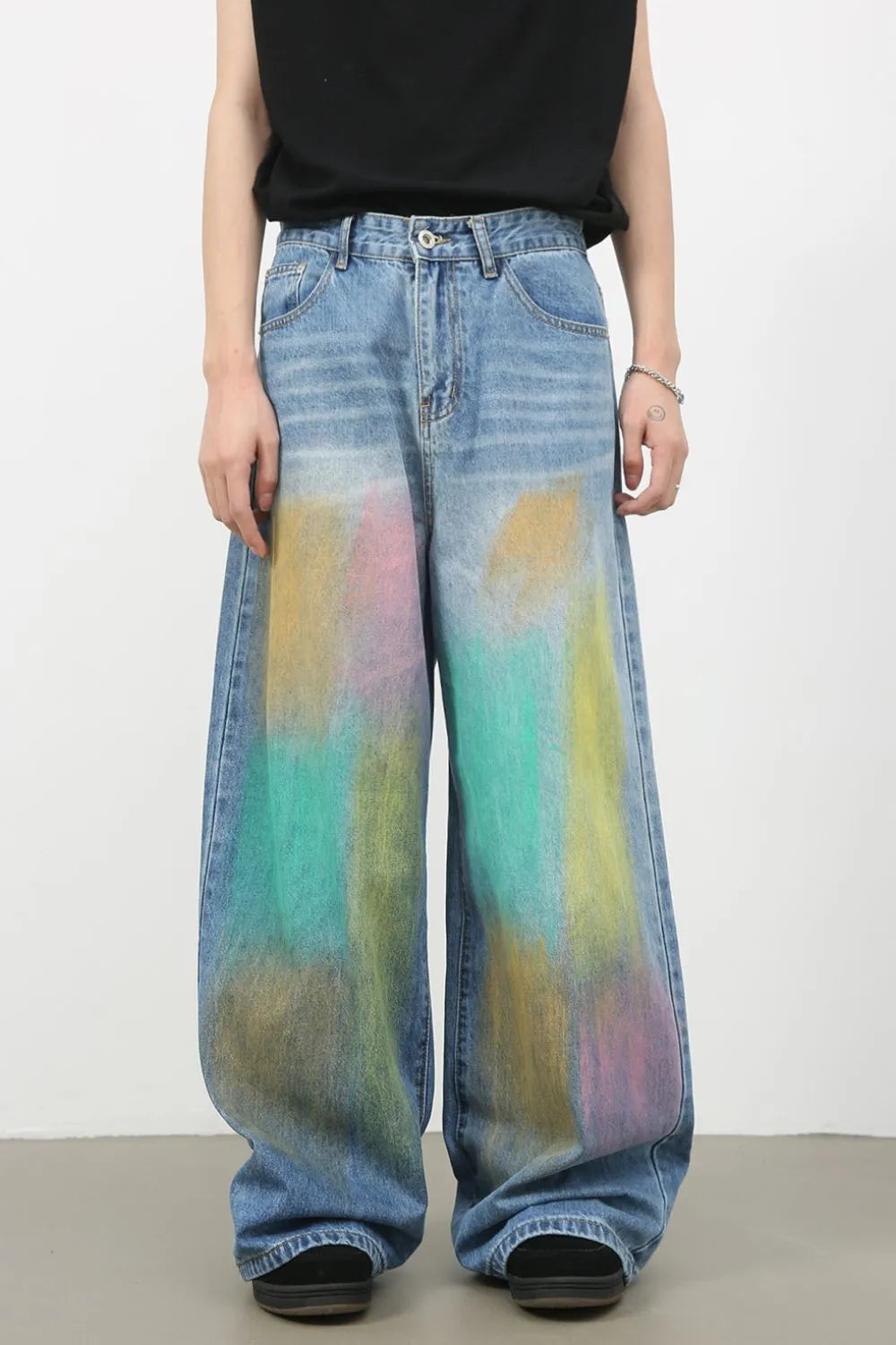 Graffiti wash wide leg denim trousers in medium with colorful abstract paint splatters.