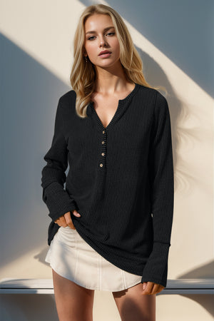 Black waffle knit henley shirt with button placket and thumbhole cuffs.