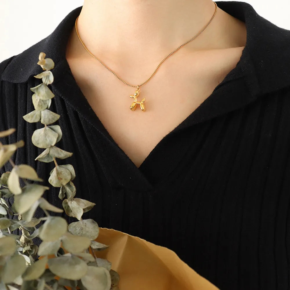 Gold balloon dog pendant necklace on a fine chain.