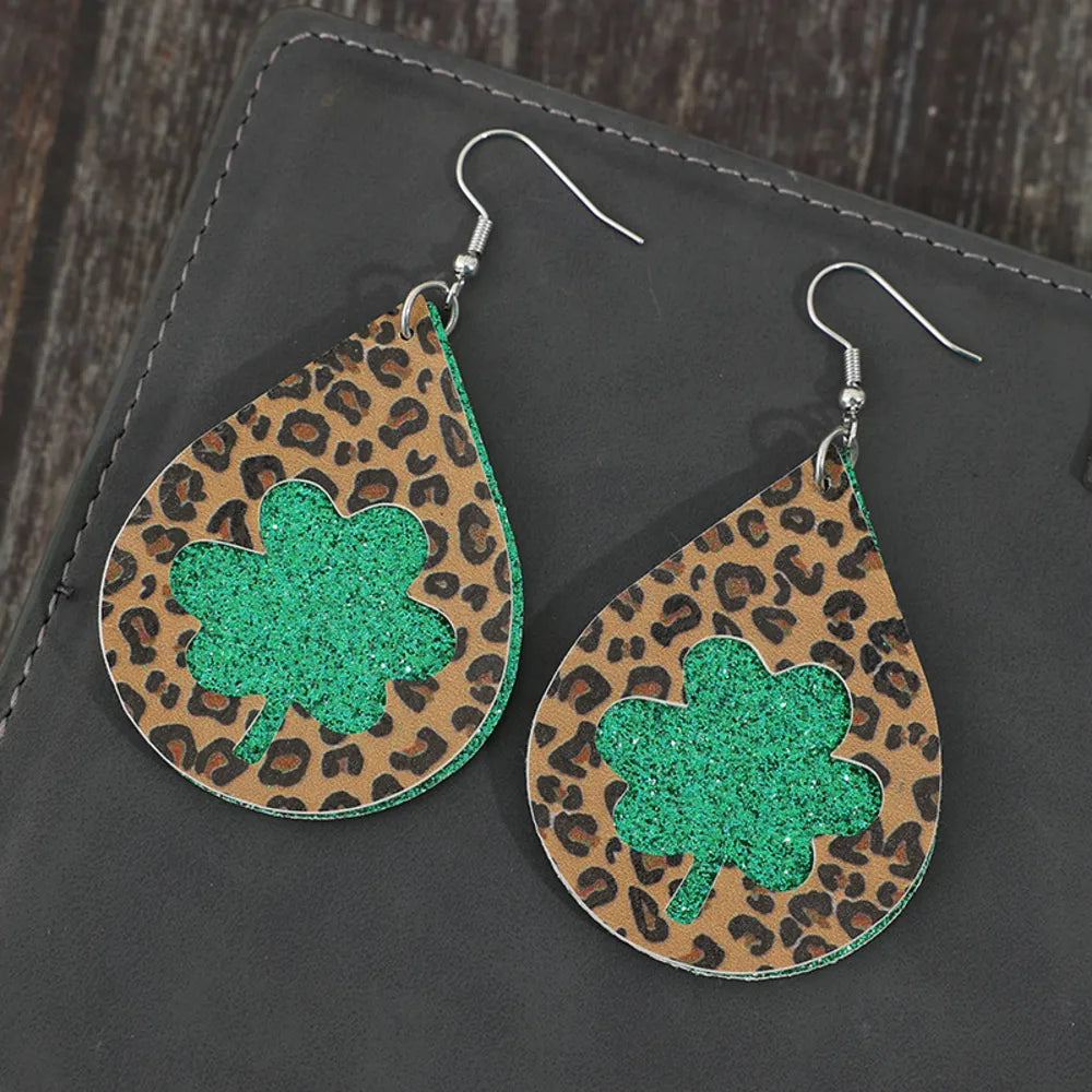 Leopard print teardrop shamrock earrings in green glitter and brown.