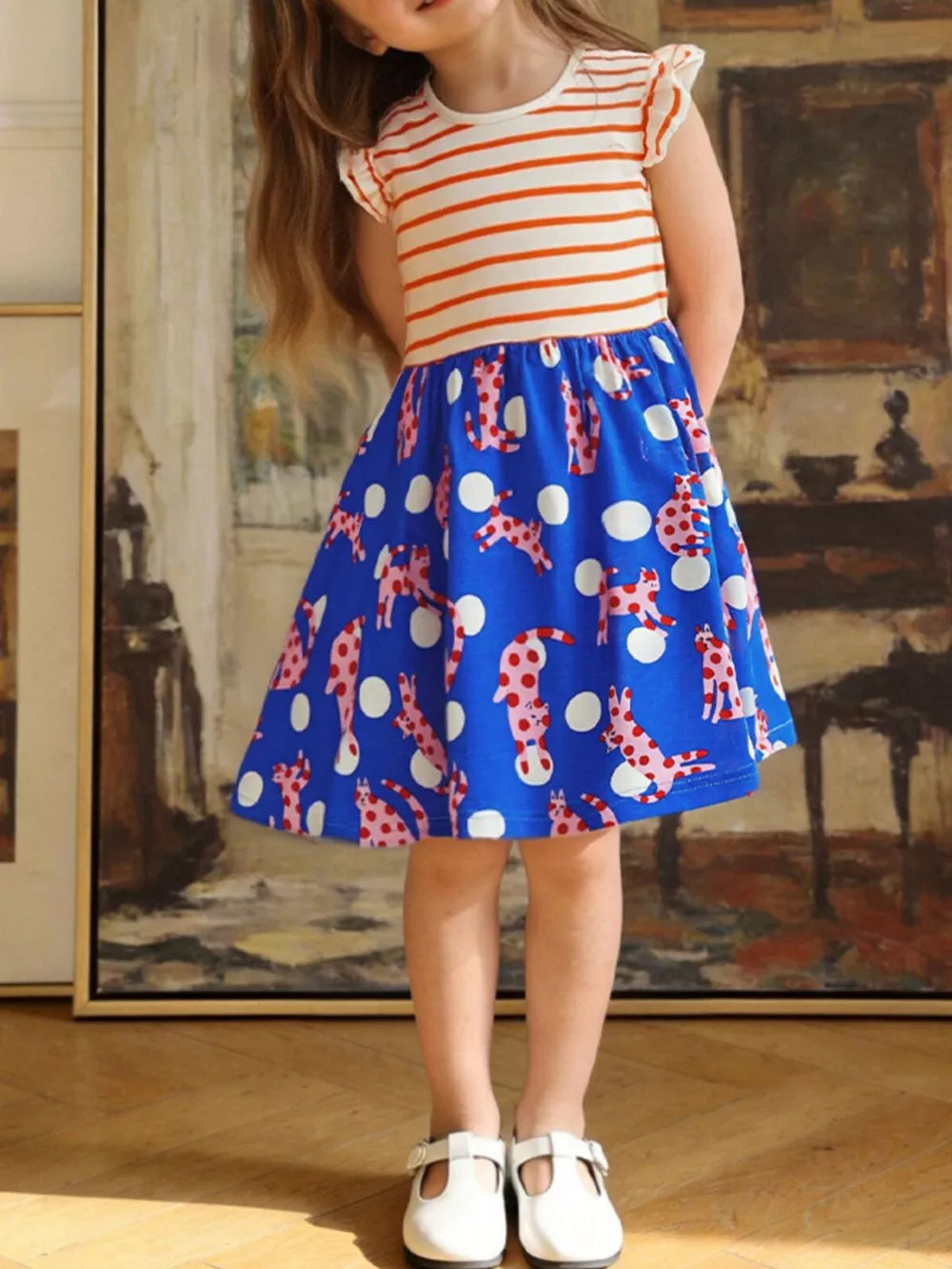 Toddler dress with orange stripe top and blue skirt with pink dog print and white polka dots.