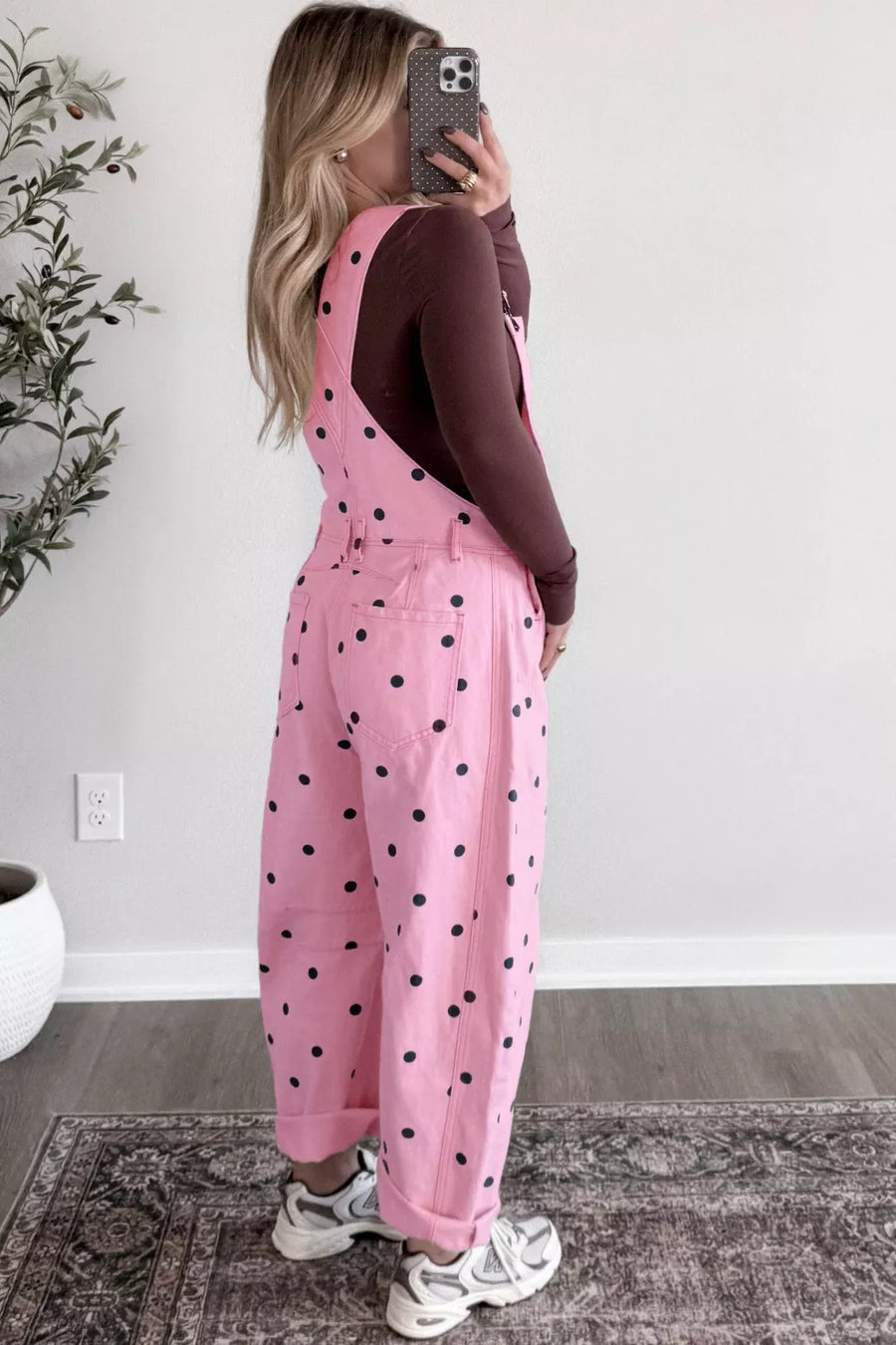 Pink polka dot denim overalls with bib pocket and barrel leg cut.