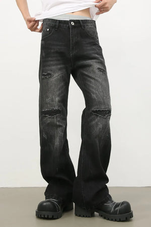 Distressed dark wash flare jeans with bleach details and ripped knees.