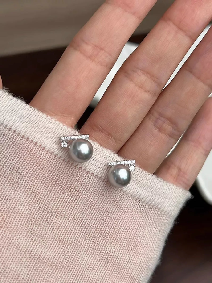 Zircon pearl stud earrings with diamond accents in light gray.