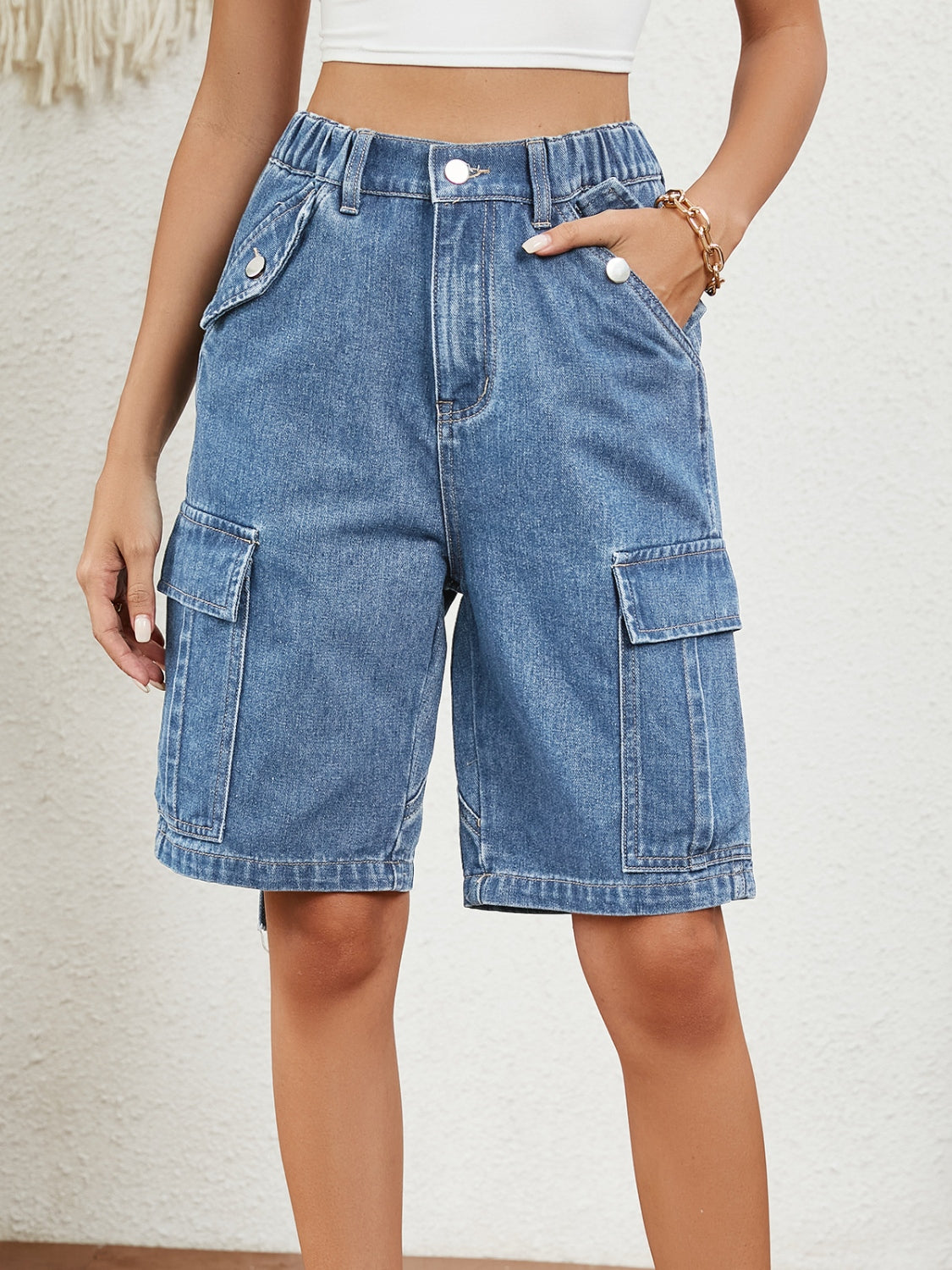 Medium wash denim Bermuda shorts with utility pocket detail and button closure