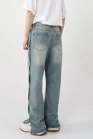 Medium wash baggy denim jeans with side slit and snap hem detail.