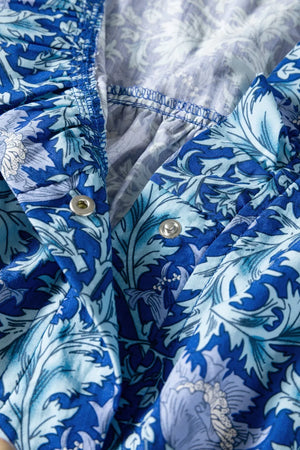 Blue floral cotton midi dress with cinched waist detail and snap closure