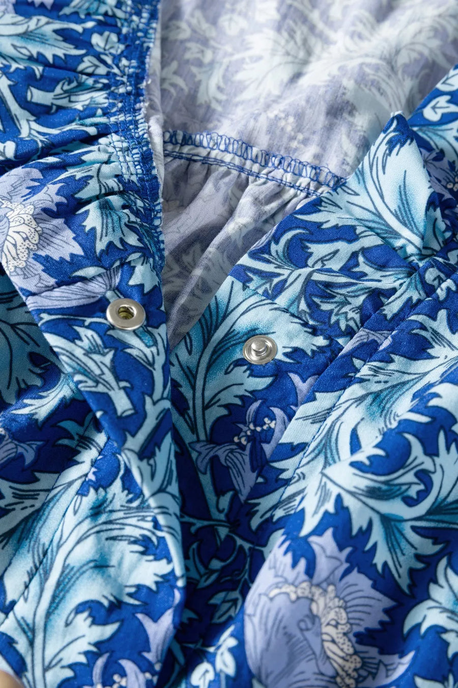 Blue floral cotton midi dress with cinched waist detail and snap closure