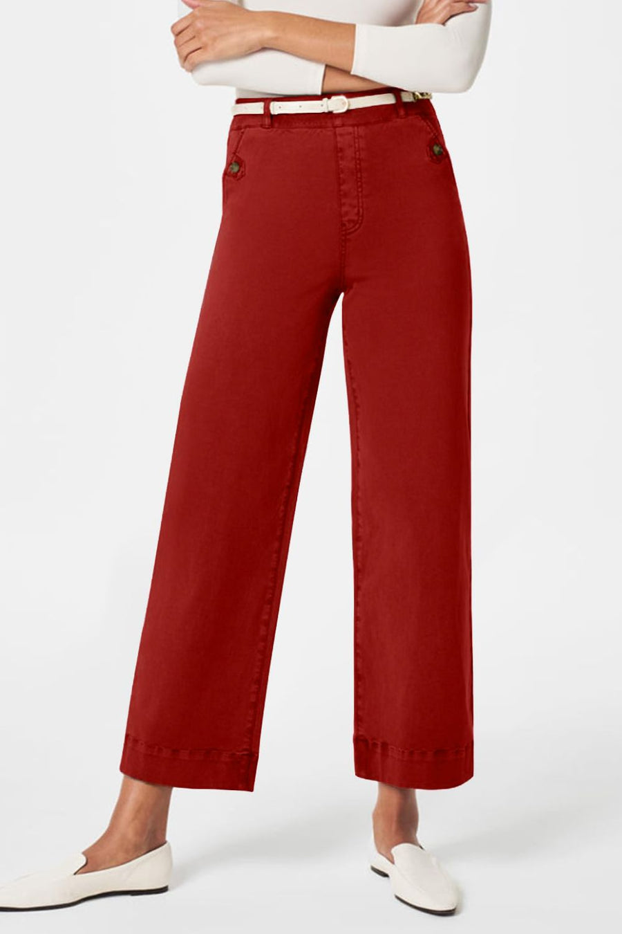 Wide-leg utility denim trousers in rust with button details and a white belt.