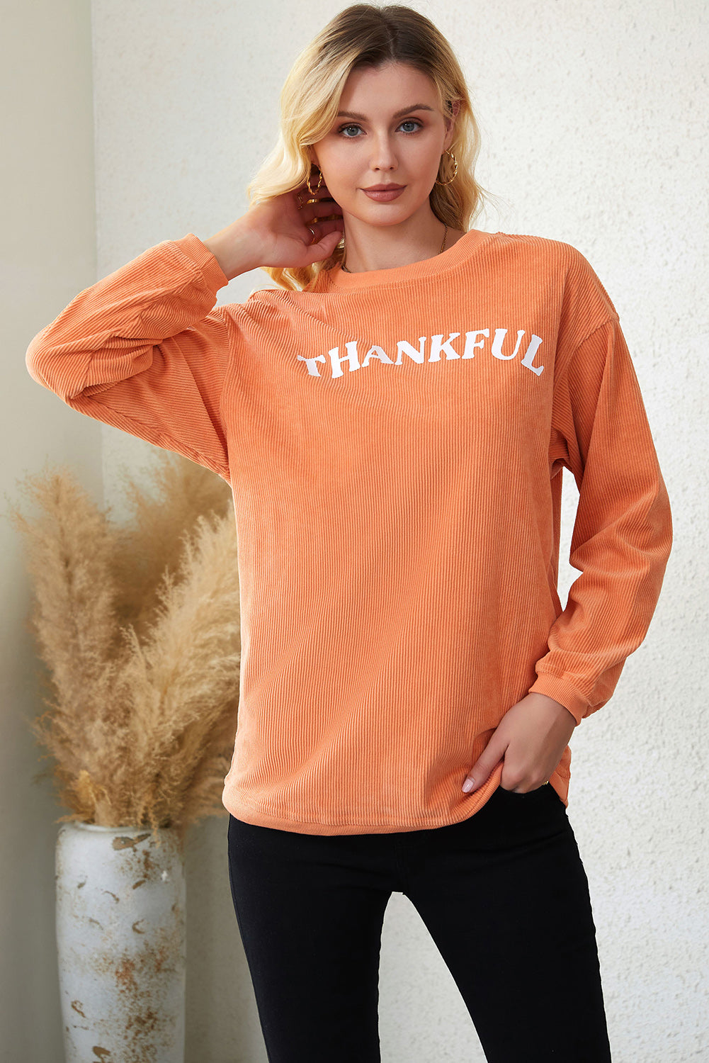 Orange corduroy sweatshirt with white "Thankful" graphic, relaxed fit, crew neck, and long sleeves.