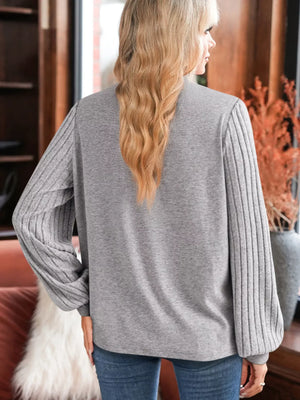 Gray ribbed knit long-sleeve top with textured sleeves and lace detail.
