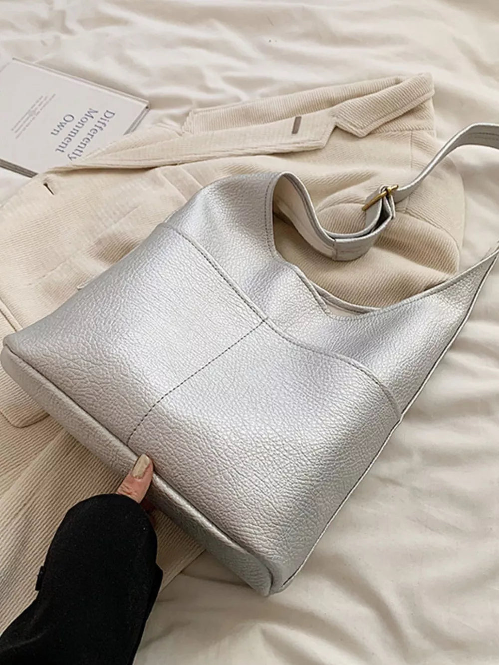 Silver textured pu leather shoulder bag with adjustable strap and gold buckle detail.
