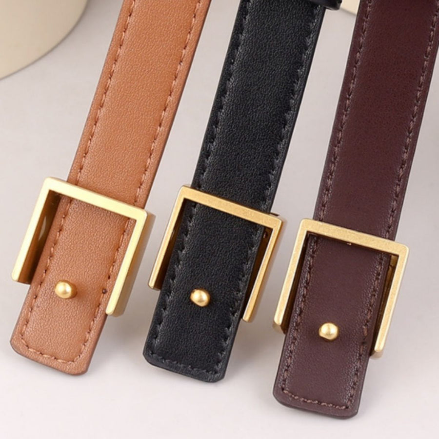 Skinny cowhide leather belts in brown, black, and olive brown with gold square buckles.