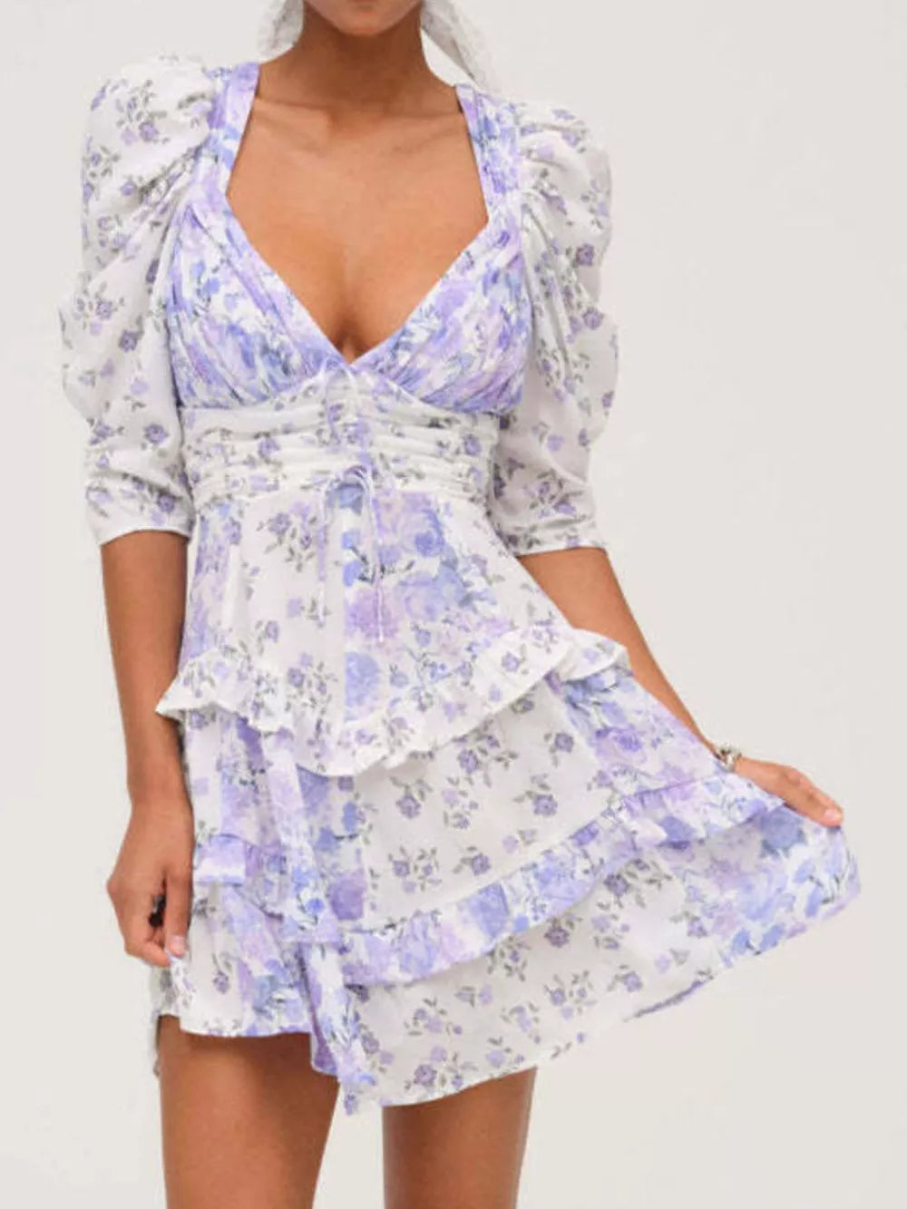 Ruched floral tie-front dress with ruffled tiers and puff sleeves in purple and white.