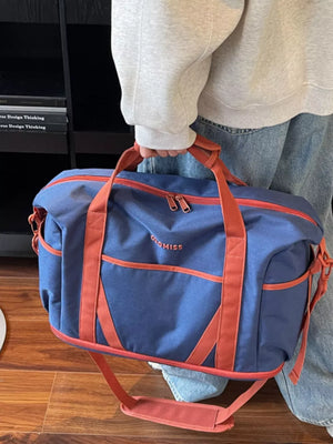 Blue duffel bag with orange trim and straps, featuring a logo and multiple pockets.