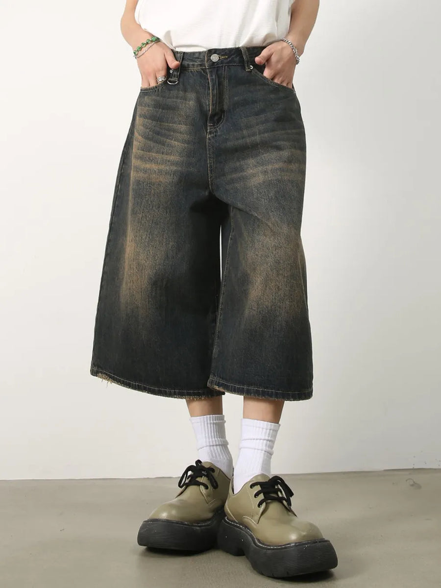 Wide-leg distressed denim culottes in dark wash with frayed hem.